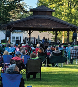 people sittiing on a parade float with blue and white umbrellas